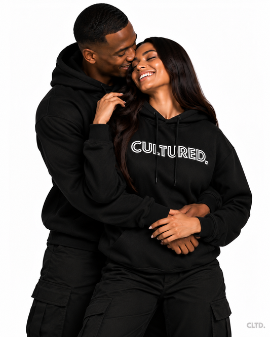 Couple wearing black CULTURED. hoodies in an affectionate embrace, subtle CLTD. watermark
