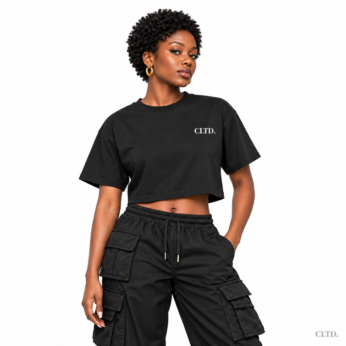 Crop Top front view — female model wearing black The Detty Made Me Do It Style 2 with cream CLTD. chest logo